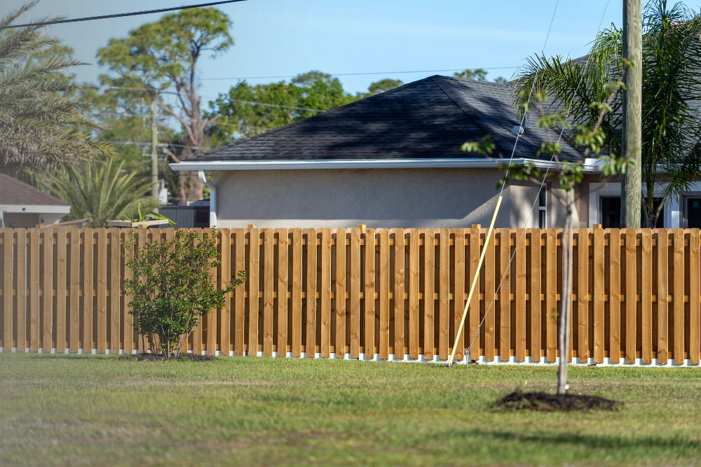 Fence installation process showing a newly constructed wooden privacy fence
